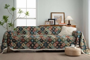 Detail of colorful geometric jacquard sofa cover with thick bohemian tassel fringe