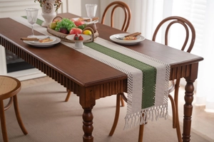 Dettaglio runner da tavola intrecciato con strisce blu e bordi in pizzo color crema