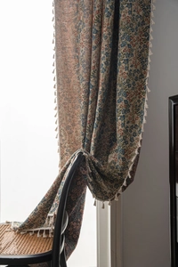 Close-up of vintage blue floral jacquard fabric with elegant white fringe tassel detail