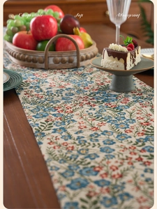 Close-up of thick floral jacquard table runner with vintage countryside fringe details