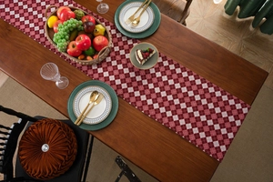 Detail of red and white checkered table runner on a dark wood table with dining tableware