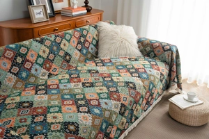 Detail of bohemian jacquard sofa blanket with colorful geometric patterns and white tassels