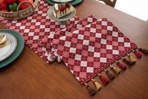 Detailed view of red and white checkered table runner with multi-colored fringe tassels
