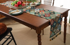 Detail of bohemian woven table runner with colorful geometric patterns and fringe tassels