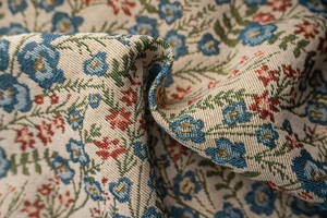 Macro detail of vintage floral jacquard fabric with blue and red flower patterns