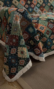 Detail shot of boho woven throw blanket with colorful geometric pattern and fringe edges
