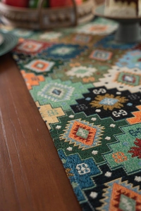 Close-up of bohemian geometric jacquard table runner with fringe on a wooden table