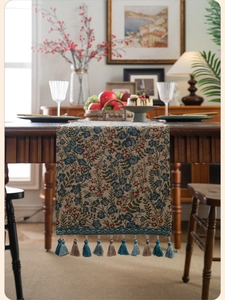 Detailed close-up of pastoral floral jacquard table runner with decorative colorful tassels