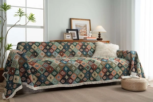 Detail of bohemian geometric jacquard throw blanket with thick fringe and diamond pattern