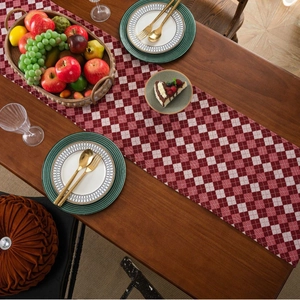 Classic red and white plaid table runner with fringe on a dark wood dining table