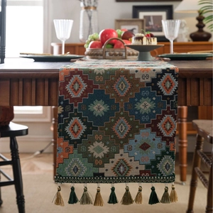 Ethnic geometric jacquard table runner with colorful tassels on a wooden table