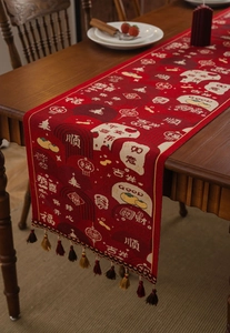 Detail of red festive table runner with traditional jacquard patterns and tassels