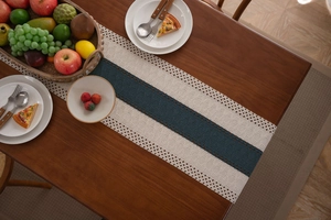 Dettaglio del runner da tavola blu navy con bordi in pizzo bianco all'uncinetto su legno