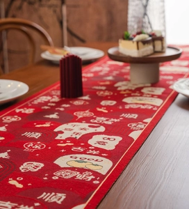 Close-up of red Chinese New Year table runner with golden festive patterns and characters