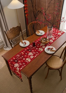 Close-up of red Chinese New Year table runner with jacquard patterns and tassels
