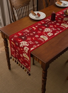 Detail of red table runner with traditional Chinese festive jacquard and brown tassels