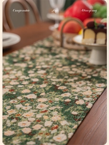 Detailed macro view of green floral jacquard table runner with fringe and thick texture