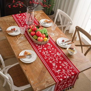 Red festive table runner with floral bird jacquard patterns and elegant tassel fringe