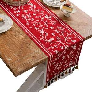 Festive red table runner with floral jacquard patterns and colorful woven tassels