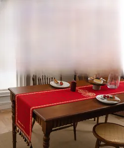 Macro-opname van rode Chinese tafelloper met gouden Fu-motieven en handgemaakte kwastjes