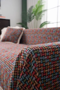 Dettaglio del copridivano jacquard verde con trama boho spessa e cuscino coordinato