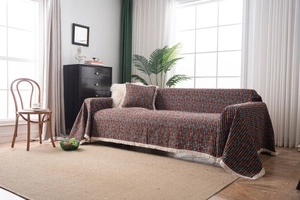 Dettaglio del copridivano jacquard verde vintage con frange e cuscino coordinato