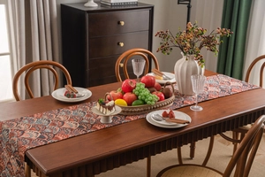 Detailed texture of jacquard table runner with ginkgo leaf pattern on a dark wood dining table