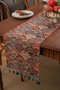 Detail showing jacquard weaving and ginkgo leaf patterns with tassels on table runner