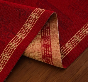 Detailopname van rode en gouden jacquardstof met traditionele feestelijke patronen