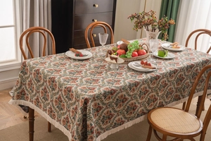 Close-up of vintage floral jacquard tablecloth with intricate tassel edge detail