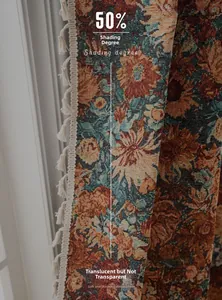Close-up of vintage floral jacquard curtain fabric with decorative off-white tassels
