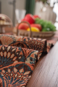 Close-up of thick jacquard table runner featuring retro orange and blue floral weaving
