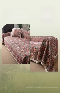 Detail of bohemian sofa cover with retro shell pattern and decorative white tassels