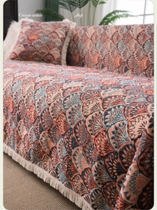 Detail of bohemian sofa cover featuring wave pattern jacquard and white tassels