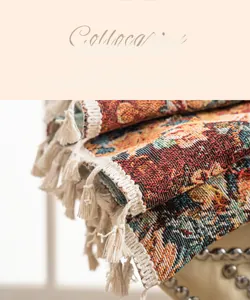 Detailed close-up of colorful floral jacquard fabric with handmade cream tassels and thick stitching