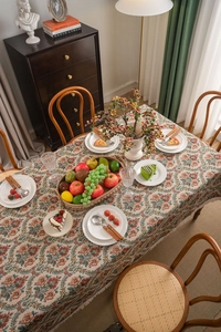 Close-up of vintage floral jacquard tablecloth with intricate patterns and tassel fringe