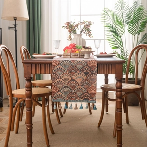 Ginkgo leaf pattern table runner with tassels on a wooden dining table for home decor