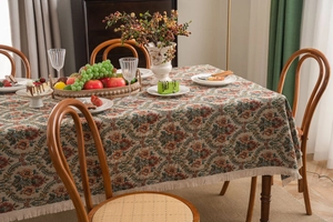 Close-up of vintage floral jacquard tablecloth with elegant cream fringe edges