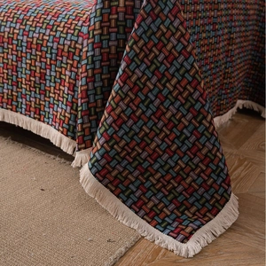 Copridivano vintage verde con motivo floreale jacquard e bordi con frange intrecciate