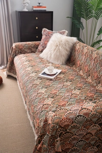 Détail d'un jeté de canapé jacquard bohème avec motif d'éventail orange vert et franges