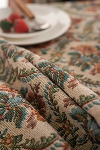 Detail of vintage woven jacquard tablecloth featuring red and blue floral patterns