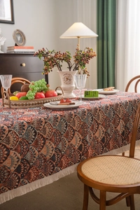 Detail of bohemian jacquard tablecloth featuring intricate patterns and white fringe trim