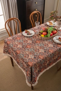 Detailed view of jacquard table cloth featuring orange and blue fan patterns with fringe