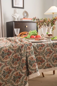 Close-up of vintage floral jacquard tablecloth with elegant white tassel fringe edges