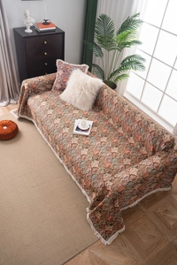 Détail de la housse de canapé style rustique avec motif jacquard et glands à franges