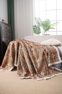 Détail d'un jeté de canapé mandala bohème avec tissage jacquard et franges blanches