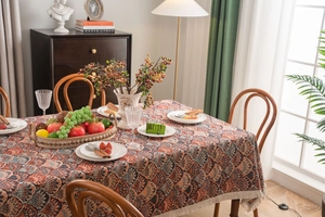 Close-up of bohemian jacquard tablecloth with fringe edges and orange fan patterns