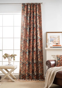 Detailed macro view of vintage floral jacquard curtain with elegant orange fringe accents