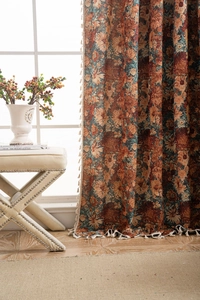 Detailed close-up of retro floral jacquard curtain fabric with white decorative tassels