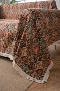 Détail de jeté de canapé jacquard avec motifs de plumes rétro et franges blanches